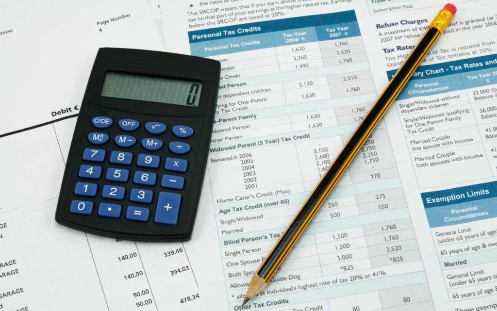 Black calculator and pencil on tax documents