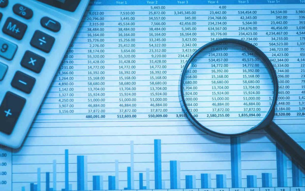 Magnifying glass over spreadsheet and calculator